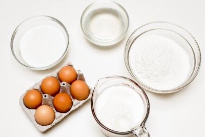 3 bowls one with flour, one with sugar and one with coconut oil also a measuring cup with milk and 6 eggs