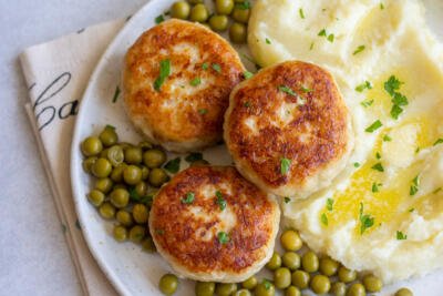 Kotleti on a palte with cucumbers and mashed potatoes