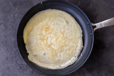 Crepe cooking in a pan.
