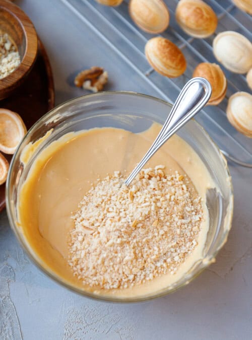 Dulce de leche buttercream in a glass bowl with cookie crumbs inside