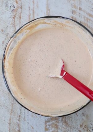 creamy Cajun sauce mixed together in a glass bowl with a red spatula
