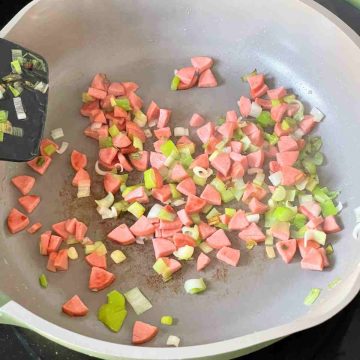 Stir fry chicken sausage spring onions in pan