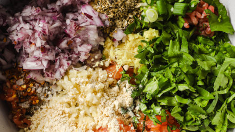 Ingredients for Chapli Kabab combined in a bowl ready to be mixed.