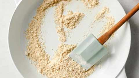 Toasted gram flour (besan) in a pan with a spatula.