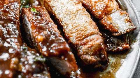 a plate of easy crockpot pork chops sliced to show juicy meat